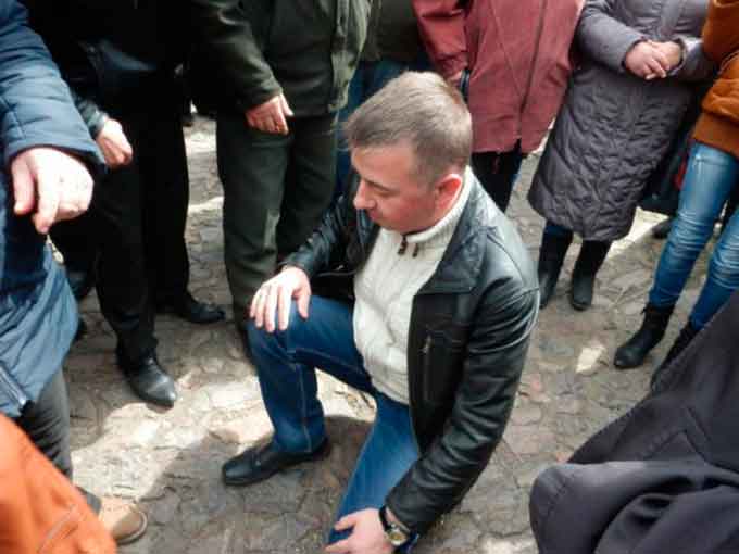 Депутат районної ради Володимир Копійченко на колінах просить пробачення в селян Лісового за те, що привіз у їхнє село тітушок із битами