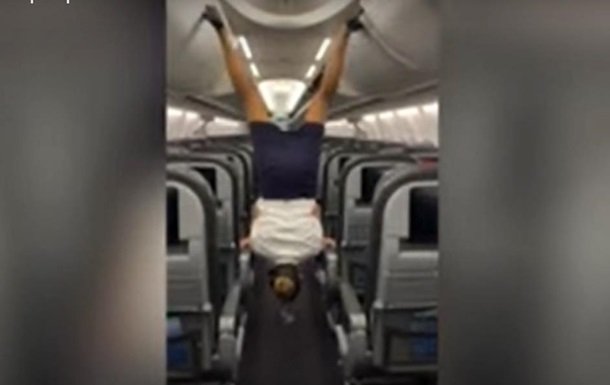 Стюардеса ногами закрила верхні багажні полиці в салоні літака (відео)